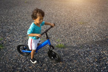 Asyalı çocuk ilk gün oyun denge bisikleti.