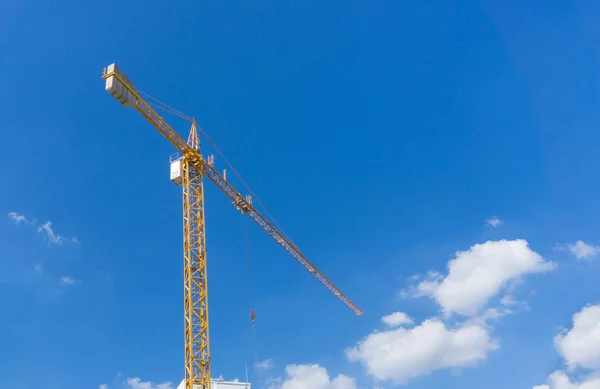 Guindaste torre de construção amarelo contra o céu azul — Fotografia de Stock