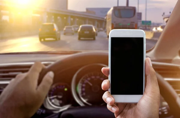 Usando um smartphone enquanto dirige um carro — Fotografia de Stock