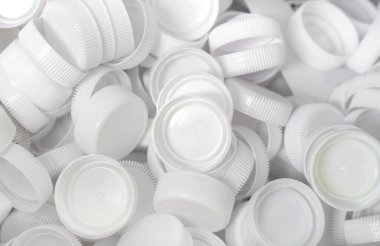 Şişelerden arta kalan beyaz plastik kapak yeniden kullanılmak üzere geri dönüştürülecek..