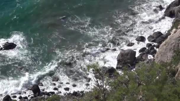 Океанские Волны Разбиваются Черные Камни Образуя Белую Пену Вода Кипит — стоковое видео