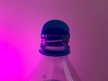 Tapon botella abierto con luz morada de fondo