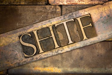 Klasik desenli grunge bakır arkaplan üzerine büyük harfli SHTF metni oluşturan gerçek otantik yazı tipi harflerinin fotoğrafı