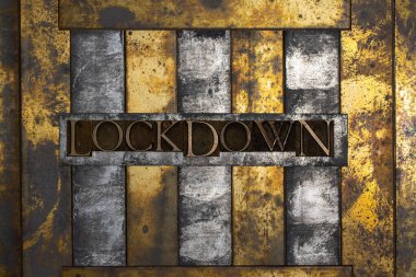 Photo of real authentic typeset letters forming Lockdown text on vintage textured grunge copper and black background  clipart