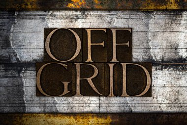 Klasik desenli grunge gümüşü ve altın arkaplan üzerinde Off Grid metni oluşturan hakiki özgün yazı tiplerinin fotoğrafı