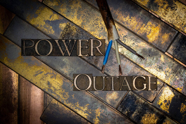 Photo of real authentic typeset letters Power Outage text on vintage textured grunge copper and gold background