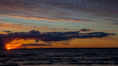 Sahilde yakıcı gün batımı, dramatik bulutlar, derin gökyüzü..