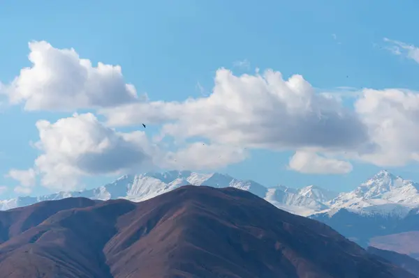 Parlak çayır, yüksek dağlar ve bulutlar