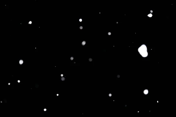 Kar fırtınası doku. Siyah arka plan, ışıkları bokeh vurdu kar taneleri havada uçan