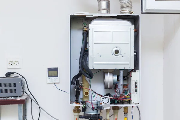 worker set up central gas heating boiler at home