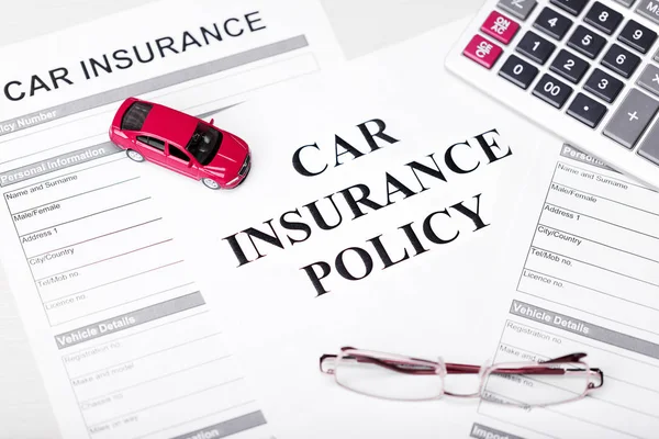 Car Insurance Policy. Document, Car, Glasses and Calculator on Table