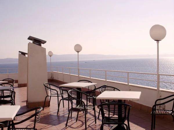 Hırvatistan 'ın Podgora kentindeki otel terası, Adriyatik denizi manzarası. Ön tarafta terasta kahve masası olan sandalyeler var. Arka planda Hvar adasına bir göz atabiliriz..