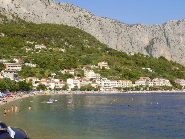 Podgora 'da küçük bir körfez, küçük özel apartman evleri olan bir deniz tatil köyü. Arka planda dağlar var..