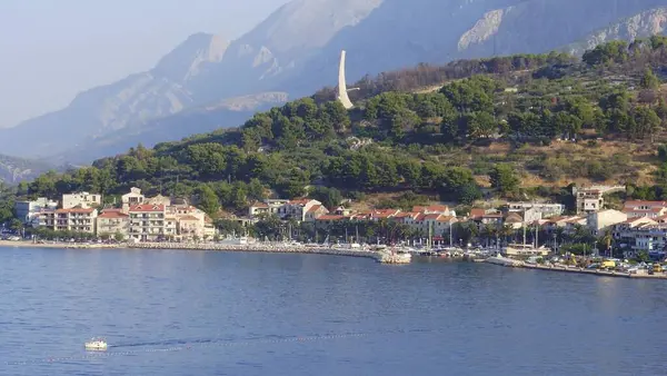 Bir orkidenin pembe çiçeği ön planda güneşle parlıyordu ve arka planda penceremin arkasında yeşil yapraklar görülüyordu..  