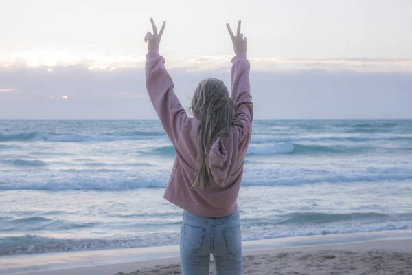 Młoda Dziewczyna Różowym Swetrze Dżinsach Stoi Plecami Fotografa Patrzy Morze — Zdjęcie stockowe