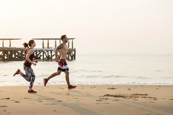 Casal correndo na praia — Fotografia de Stock
