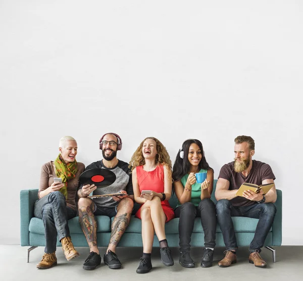 Folk sitter på soffan med enheter — Stockfoto