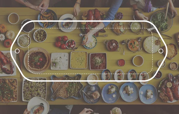 Vrienden eten aan de tafel met verschillende voedsel — Stockfoto