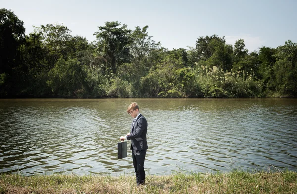 Empresario con maletín en el río , — Foto de Stock