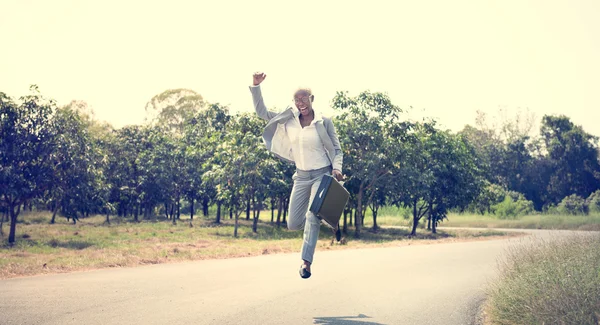 Бизнесмен на открытом воздухе прыгает с кейсом — стоковое фото