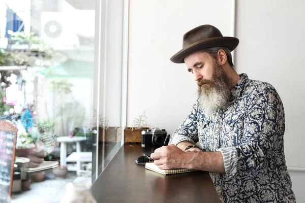 Man met baard schrijven van notities — Stockfoto