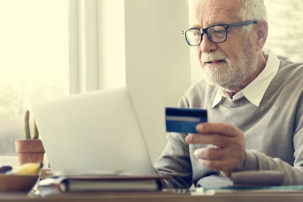 old man holding credit card