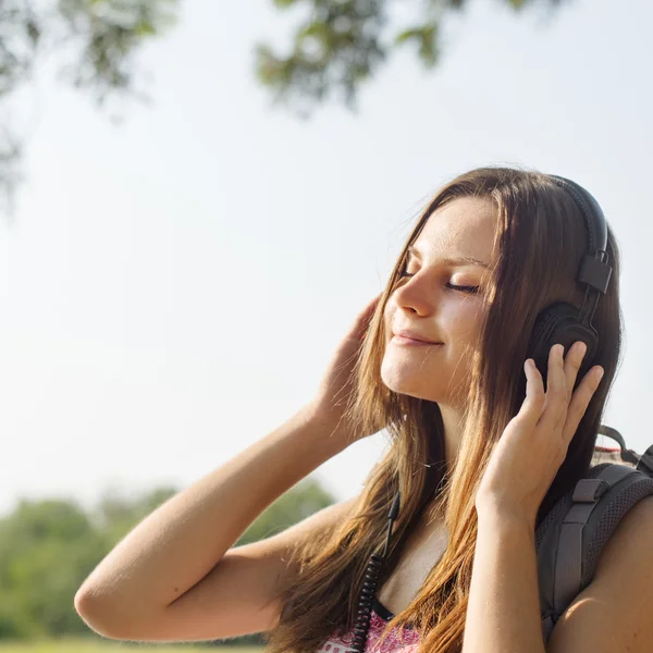 Mulher ouvindo música em fones de ouvido — Fotografia de Stock