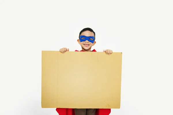 Rapaz super-herói com papelão nas mãos — Fotografia de Stock