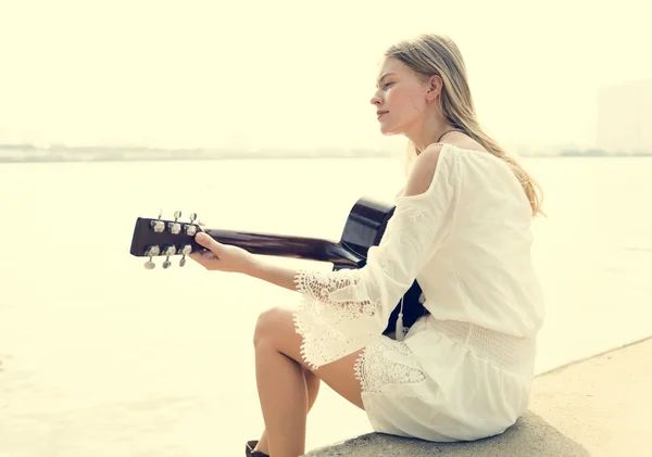 Menina loira tocando guitarra acústica — Fotografia de Stock