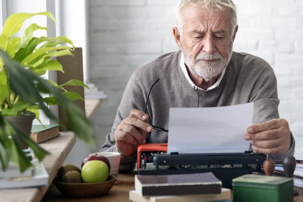 Человек пишет письмо на пишущей машинке — стоковое фото
