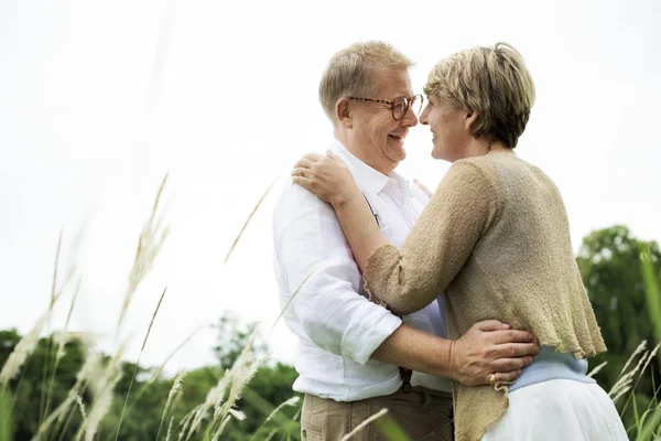 Bejaarde echtpaar omarmen buitenshuis — Stockfoto