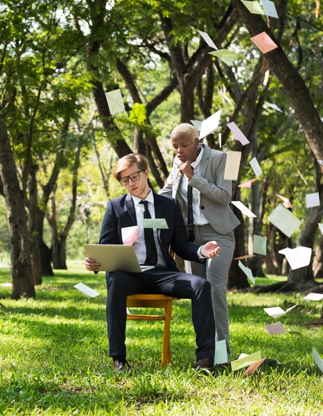 Zakenman en zakenvrouw met laptop op park — Stockfoto
