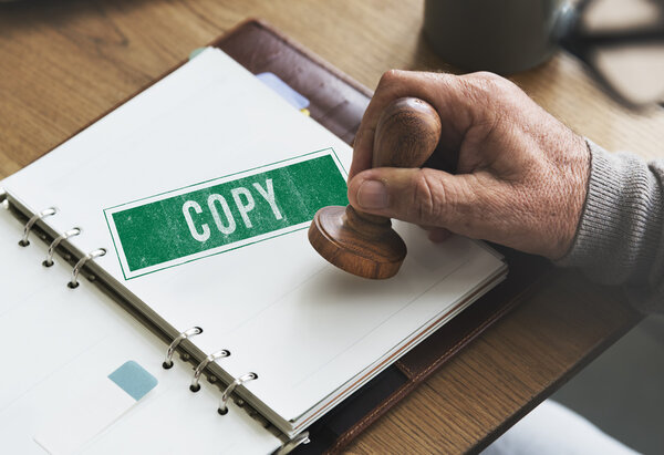 человек ставит печать на бумажной тетради
