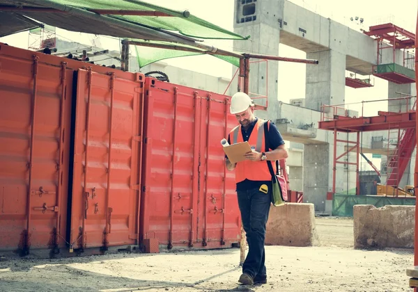 Trabalhador da construção civil com plano de arquitetura — Fotografia de Stock