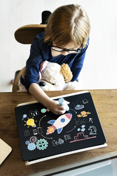 Малюк грає і малює на дошці — стокове фото