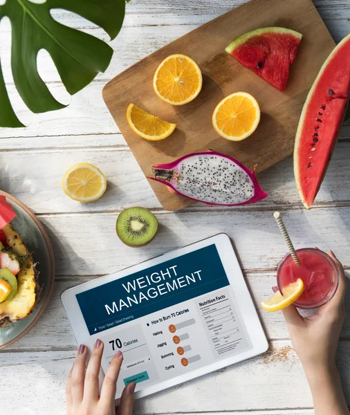 Holztisch mit Früchten und digitalem Tablet — Stockfoto