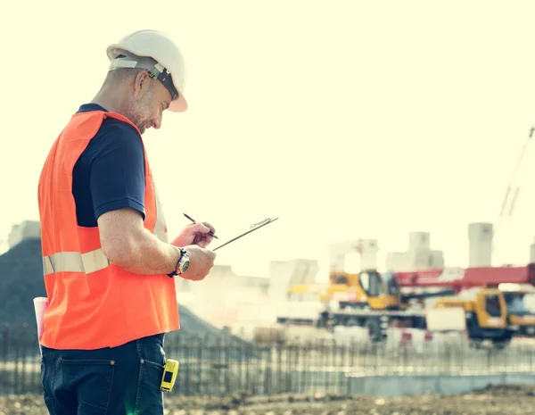 Obrero de la construcción con plan de arquitectura —  Fotos de Stock