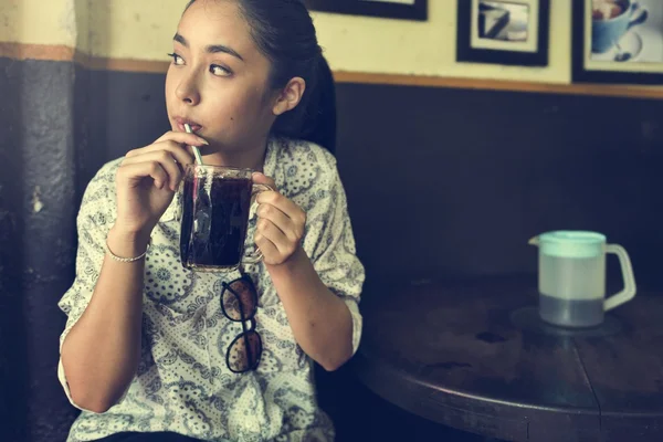Asiatisk kvinna i café håller cup — Stockfoto