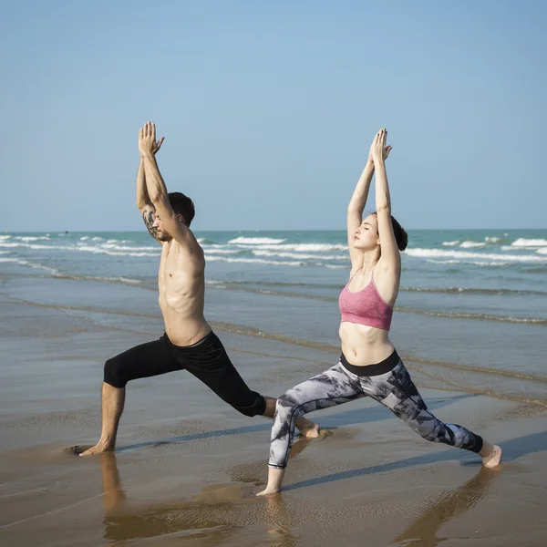 Coppia che fa yoga sulla spiaggia — Foto Stock