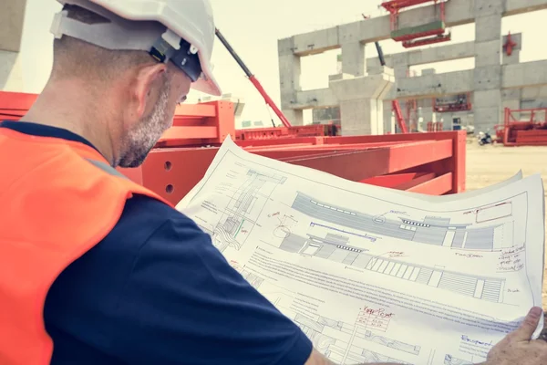 Obrero de la construcción con plan de arquitectura —  Fotos de Stock