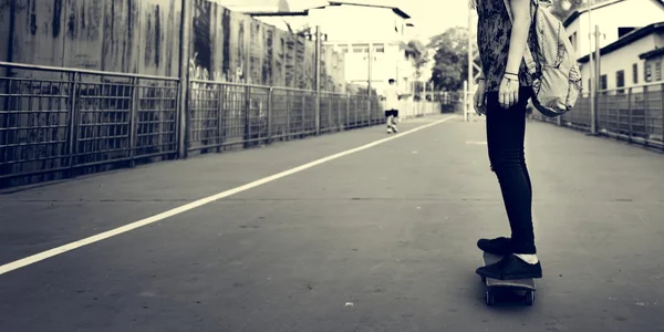 Kvinna som rider på skateboard i city — Stockfoto