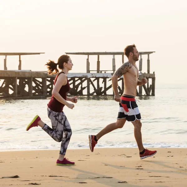 ビーチを走るカップル — ストック写真