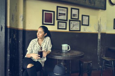 Asyalı kadın Kupası tutan Cafe