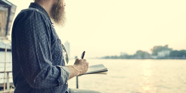 красивый пожилой человек пишет заметки
