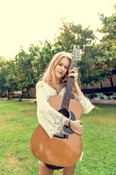 Blond žena objímala akustická kytara — Stock fotografie