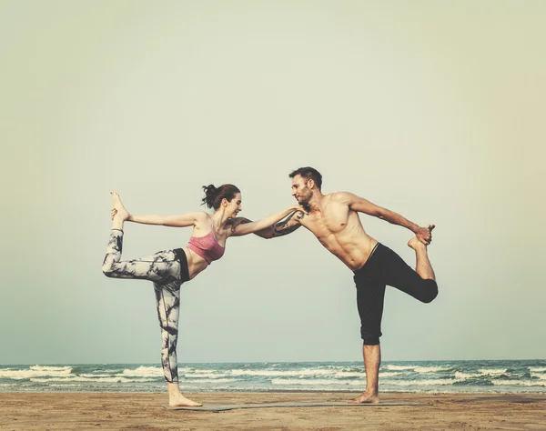 Пара робить йогу на пляжі — стокове фото