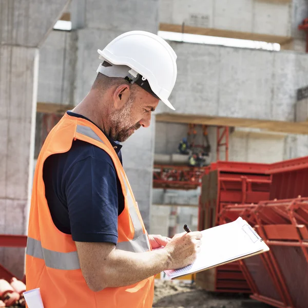 Obrero de la construcción con plan de arquitectura — Foto de Stock