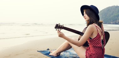 paket üzerinde oturan ve gitar çalmak bir kadın