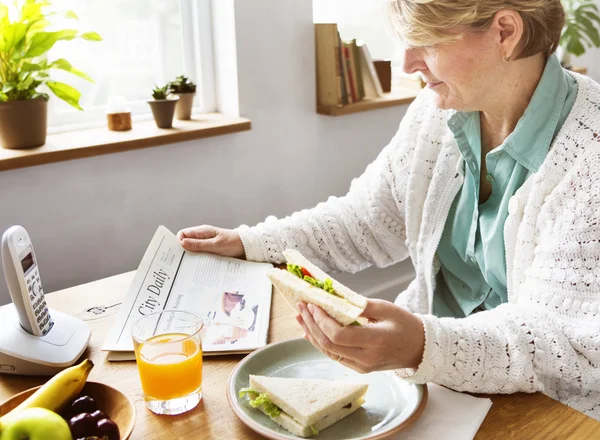 Senior vrouw eten ontbijt — Stockfoto