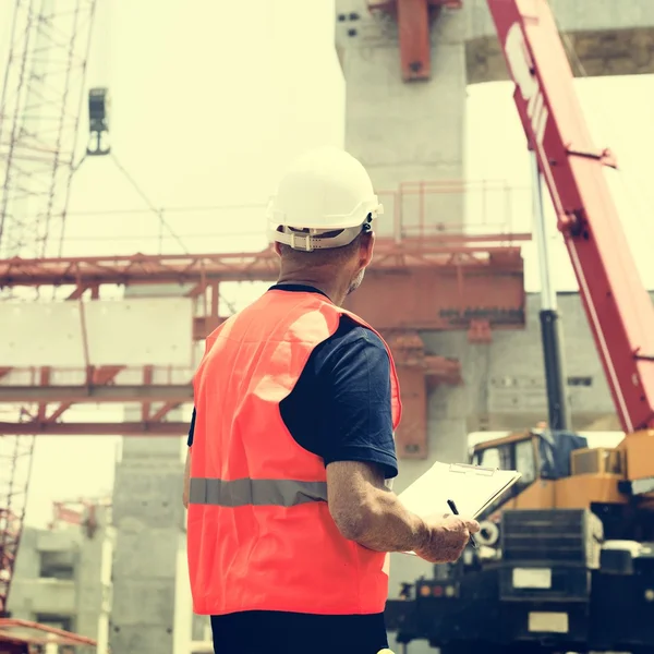 Trabalhador da construção civil com plano de arquitetura — Fotografia de Stock